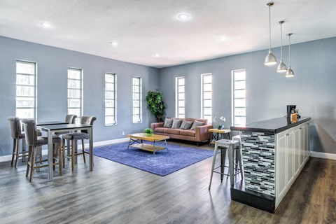 a living room with a bar and a dining room with chairs and a couch